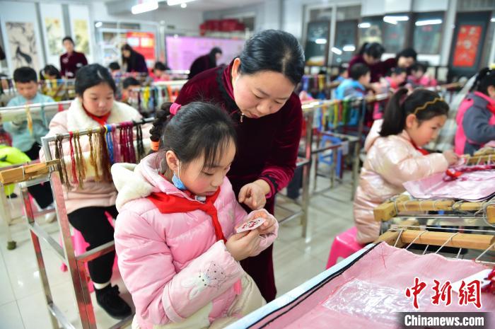 江西省級(jí)非遺豫章繡傳承人手把手指導(dǎo)小學(xué)生繡制2022年北京冬奧會(huì)吉祥物“冰墩墩”形象?！∮髟屏?攝