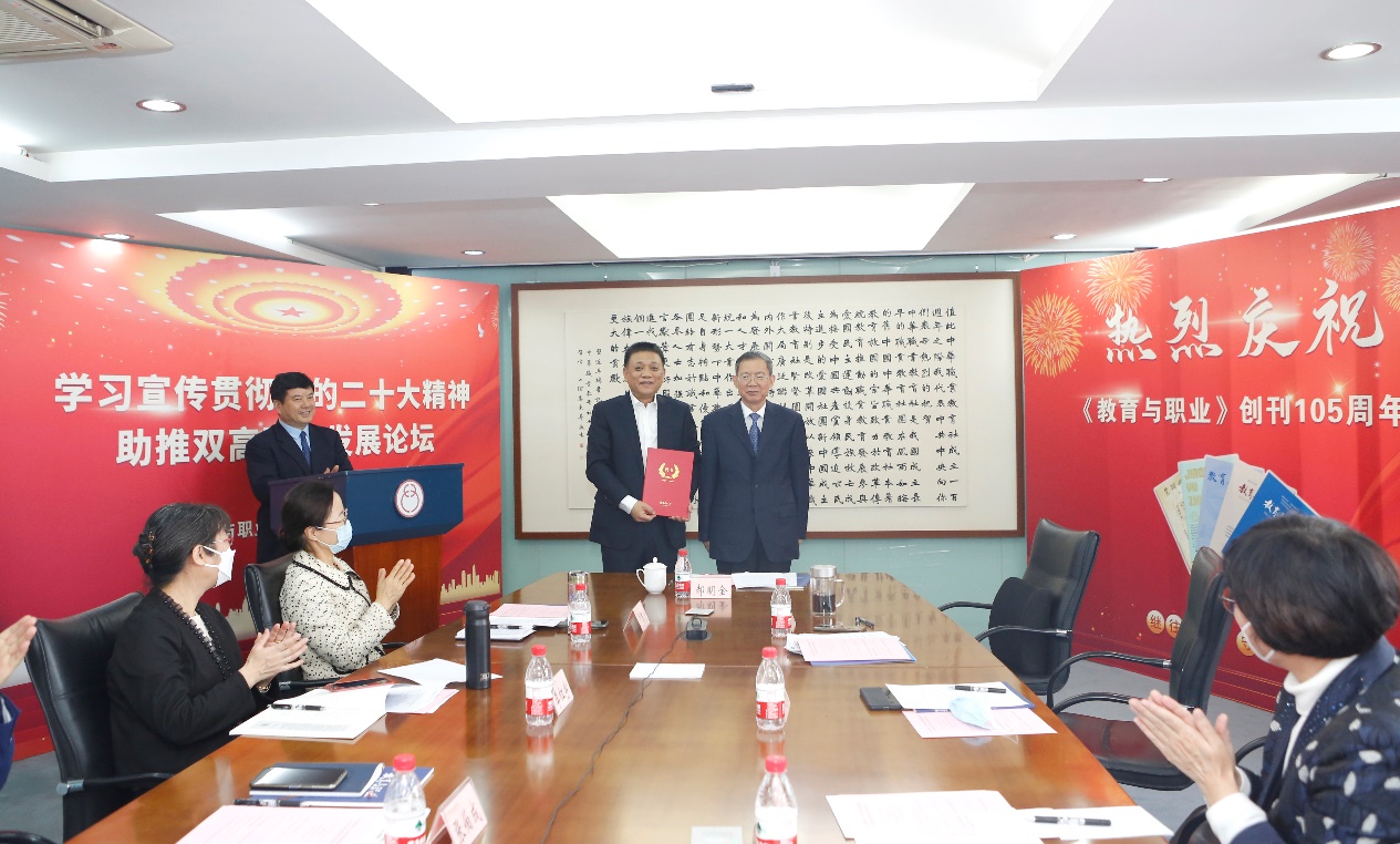 郝明金為《教育與職業(yè)》雜志編委代表陳曉明頒發(fā)聘書。中華職教社供圖