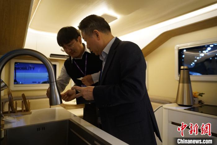 圖為參展商向觀眾介紹房車(chē)內(nèi)部設(shè)計(jì)?！⑿?攝