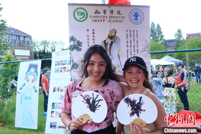 孩子們展示自己的吹墨畫團(tuán)扇作品。　魯汶孔子學(xué)院供圖