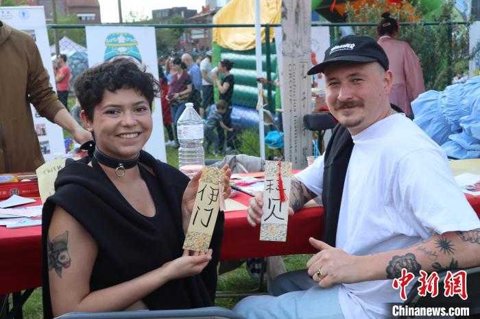 當(dāng)?shù)孛癖娫跐h字體驗(yàn)工作坊展示自己手寫的中文名書簽?！◆斻肟鬃訉W(xué)院供圖