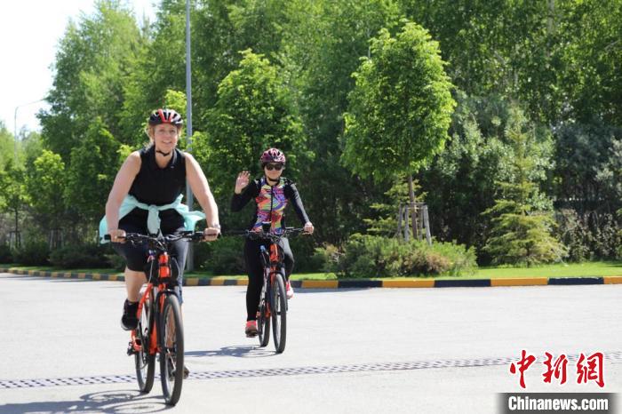 亞信副秘書長遲方(右一)與聯(lián)合國駐哈協(xié)調(diào)員在騎行活動中?！喰琶貢幑﹫D