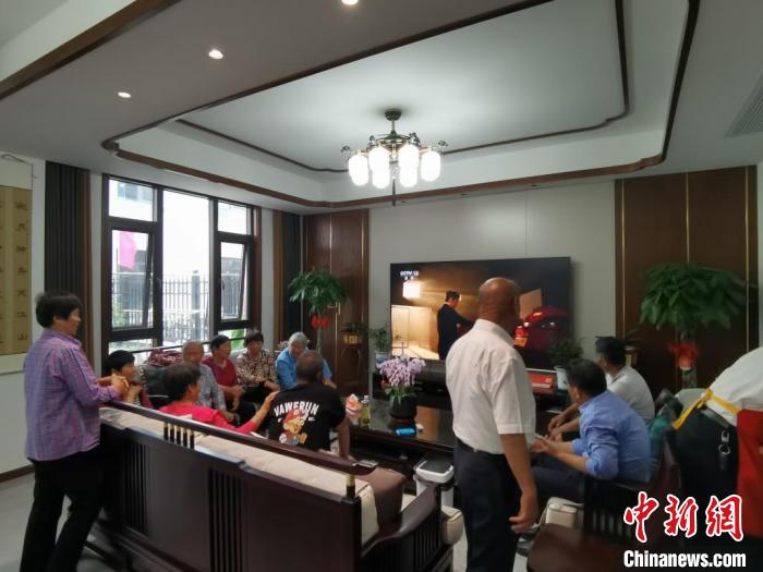 親友們集中在費(fèi)俊龍家中觀看返程的視頻?！＄娚?攝