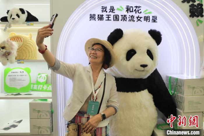 美國華視總裁楊蓮花與大熊貓文創(chuàng)產(chǎn)品合影?！⊥趵?攝
