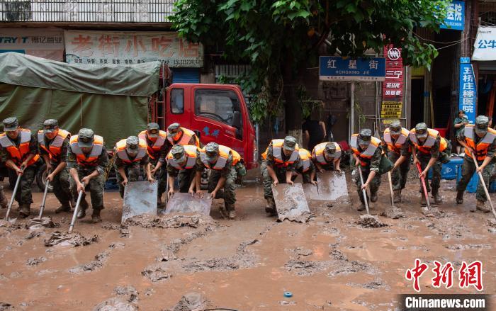 7月4日，萬州區(qū)五橋街道，武警官兵清理街道上的淤泥。　冉孟軍 攝