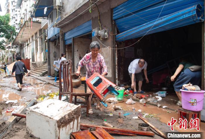 7月4日，萬州區(qū)五橋街道，洪水退去后，居民搶救生活物資?！∪矫宪?攝
