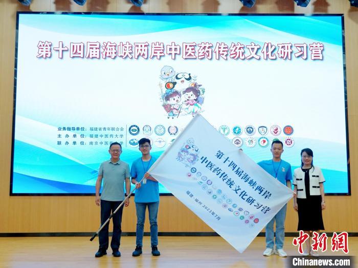 共青團福建省委副書記吳雪(右一)、福建中醫(yī)藥大學黨委副書記林羽(左一)為兩岸學生代表頒授營旗?！≡S燁婷 攝