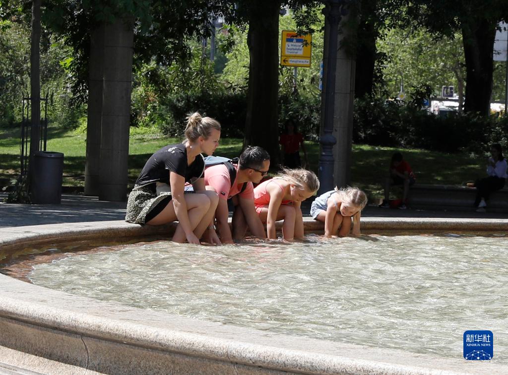 7月8日，人們?cè)诘聡ㄌm克福的一處噴泉玩水。近日，德國法蘭克福逐漸迎來暑熱天氣。新華社記者 張帆 攝