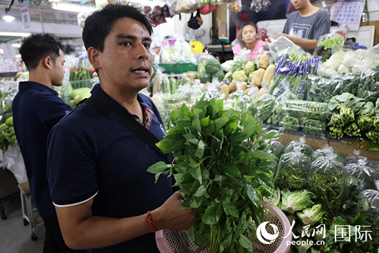 7月19日，泰國曼谷藍(lán)象餐廳員工向參加活動(dòng)的多國代表介紹如何挑選新鮮蔬菜。 人民網(wǎng)記者 張矜若攝
