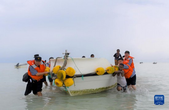 7月21日，中國海軍“和平方舟”號醫(yī)院船醫(yī)護人員涉水登島，前往基里巴斯一診療點。新華社記者 黎云 攝