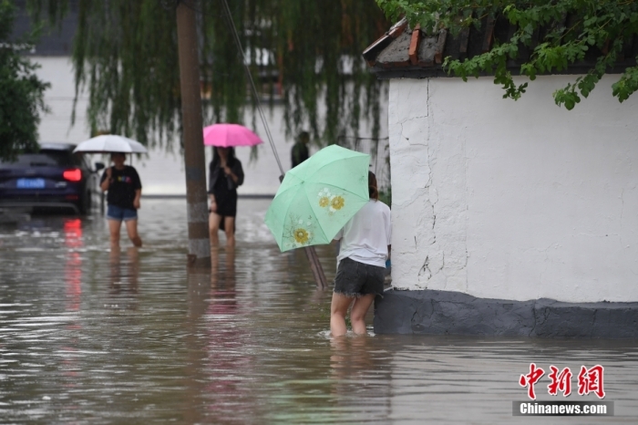 7月31日，市民行走在雨中的北京房山區(qū)瓦窯頭村。北京市氣象臺當(dāng)日10時發(fā)布分區(qū)域暴雨紅色預(yù)警信號。北京市水文總站發(fā)布洪水紅色預(yù)警，預(yù)計當(dāng)日12時至14時，房山區(qū)大石河流域?qū)⒊霈F(xiàn)紅色預(yù)警標(biāo)準(zhǔn)洪水。<a target='_blank' href='/'><p  align=