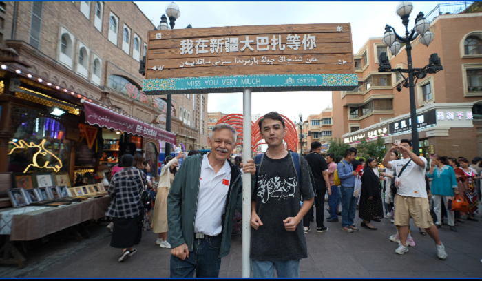 潘維廉和維吾爾族青年伊木蘭“打卡”大巴扎。主辦方供圖