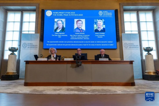 10月3日，在瑞典斯德哥爾摩舉行的2023年諾貝爾物理學獎公布現(xiàn)場，屏幕上顯示獎項得主皮埃爾·阿戈斯蒂尼（左）、費倫茨·克勞斯（中）和安妮·呂利耶的照片。新華社發(fā)（魏學超攝）