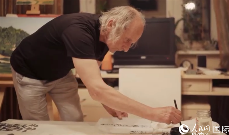 伊戈?duì)枴げ紶枛|諾夫在畫(huà)作上題詞。人民網(wǎng)記者 馬天翼攝