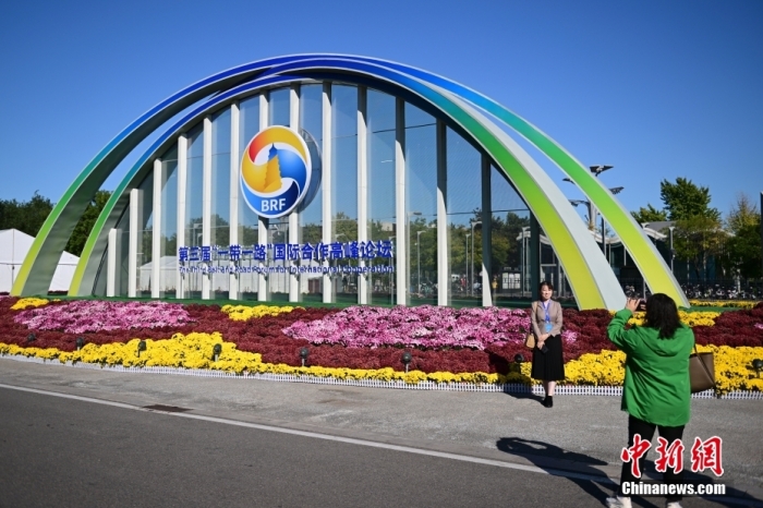 10月15日，北京，工作人員在國(guó)家會(huì)議中心外的第三屆“一帶一路”國(guó)際合作高峰論壇景觀布置前拍照留念。當(dāng)日，位于國(guó)家會(huì)議中心的第三屆“一帶一路”國(guó)際合作高峰論壇新聞中心啟動(dòng)試運(yùn)行。據(jù)悉，第三屆“一帶一路”國(guó)際合作高峰論壇將于10月17日至18日在北京舉行。<a target='_blank' href='/'><p  align=