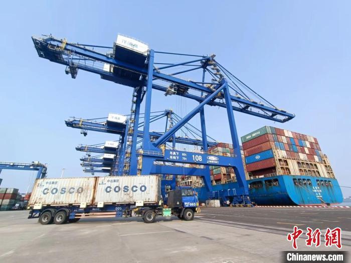 圖為海南洋浦國(guó)際集裝箱碼頭，卡車將集裝箱從后方堆場(chǎng)運(yùn)往碼頭裝卸區(qū)?！?jiān)潞?攝