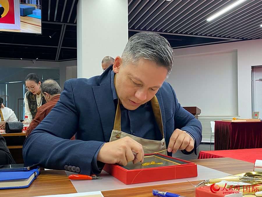 2023“一帶一路”媒體合作論壇聯(lián)合采訪團(tuán)團(tuán)員，親身體驗(yàn)景泰藍(lán)工藝。人民網(wǎng)記者 于洋攝