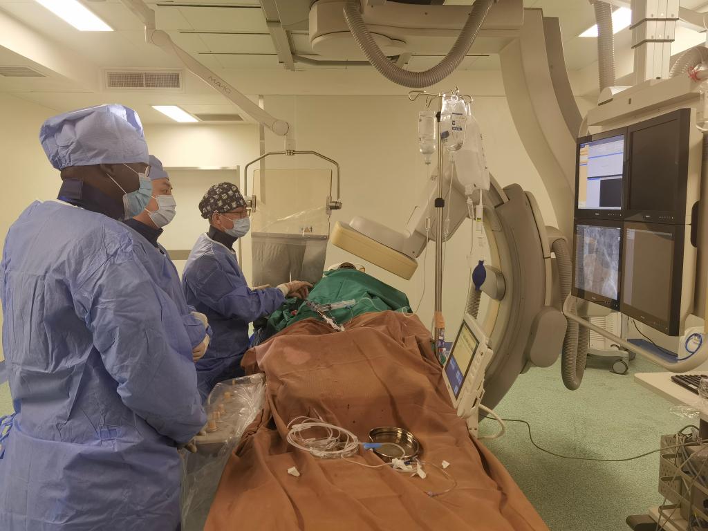 中國第29批援幾內(nèi)亞醫(yī)療隊(duì)隊(duì)員、首都醫(yī)科大學(xué)附屬北京天壇醫(yī)院心內(nèi)科副主任醫(yī)師王汝朋（右一）正在給患者做手術(shù)。（北京天壇醫(yī)院供圖）