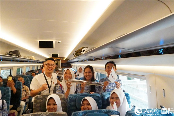 第一次乘坐雅萬(wàn)高鐵動(dòng)車組的學(xué)生們與動(dòng)車組模型合影。人民網(wǎng)記者曹師韻攝