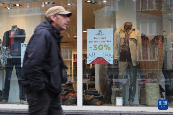   10月31日，一名男子從比利時布魯塞爾一家貼有打折信息的店鋪前走過。新華社記者 趙丁喆 攝