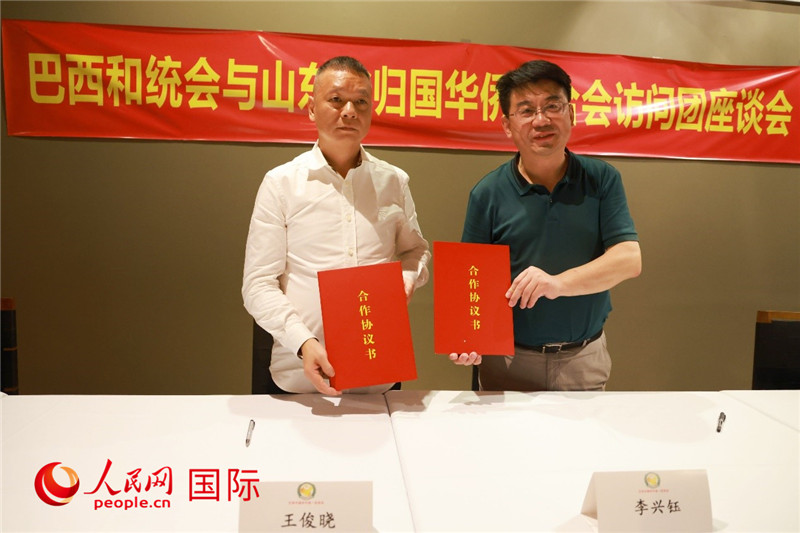 中國僑聯(lián)副主席、山東省僑聯(lián)主席李興鈺（右）與巴西和統(tǒng)會會長王俊曉簽署合作協(xié)議書。人民網(wǎng)記者 陳海琪攝