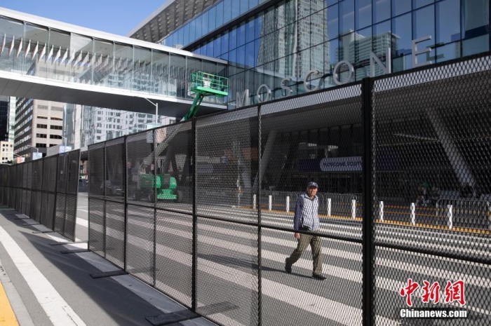 當(dāng)?shù)貢r(shí)間11月10日，一名行人從美國(guó)舊金山莫斯康中心周圍的金屬圍欄旁經(jīng)過。隨著亞太經(jīng)合組織(APEC)第三十次領(lǐng)導(dǎo)人非正式會(huì)議臨近，作為會(huì)議場(chǎng)地的莫斯康中心附近出現(xiàn)金屬圍欄，執(zhí)勤警察也大幅增加。<a target='_blank' href='/'><p  align=