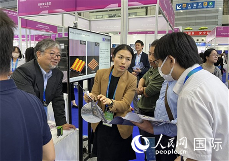 工作人員向參觀者介紹超級(jí)噴墨技術(shù)。（人民網(wǎng)記者 陳思攝）