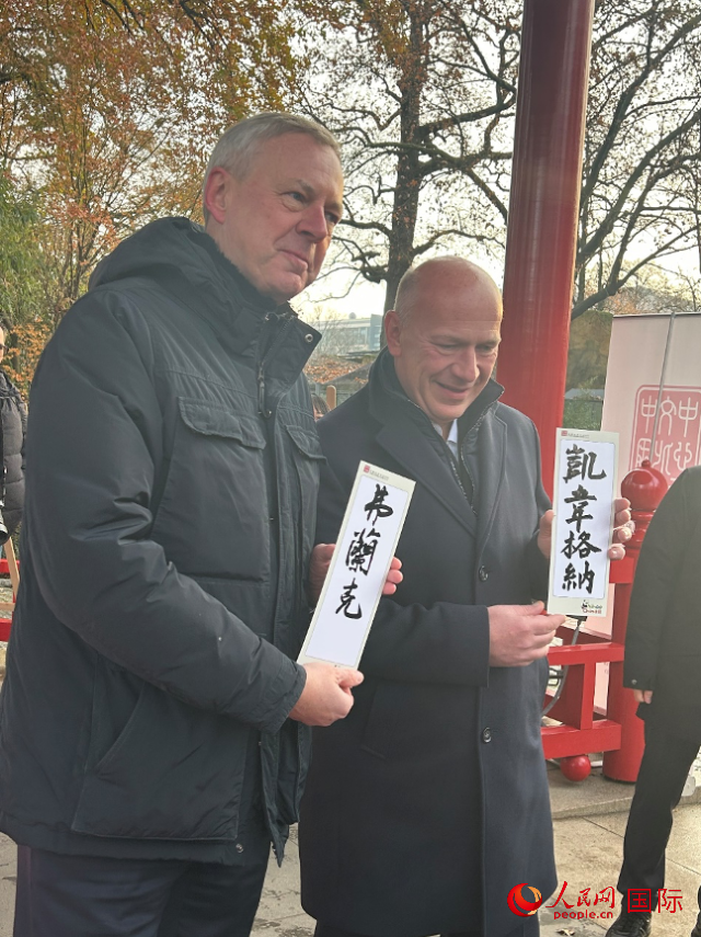 柏林市長韋格納（右）、動物園監(jiān)事會主席布魯克曼（左）手持中國文化中心工作人員現(xiàn)場手書的中文名字。人民網(wǎng)記者 徐馨攝