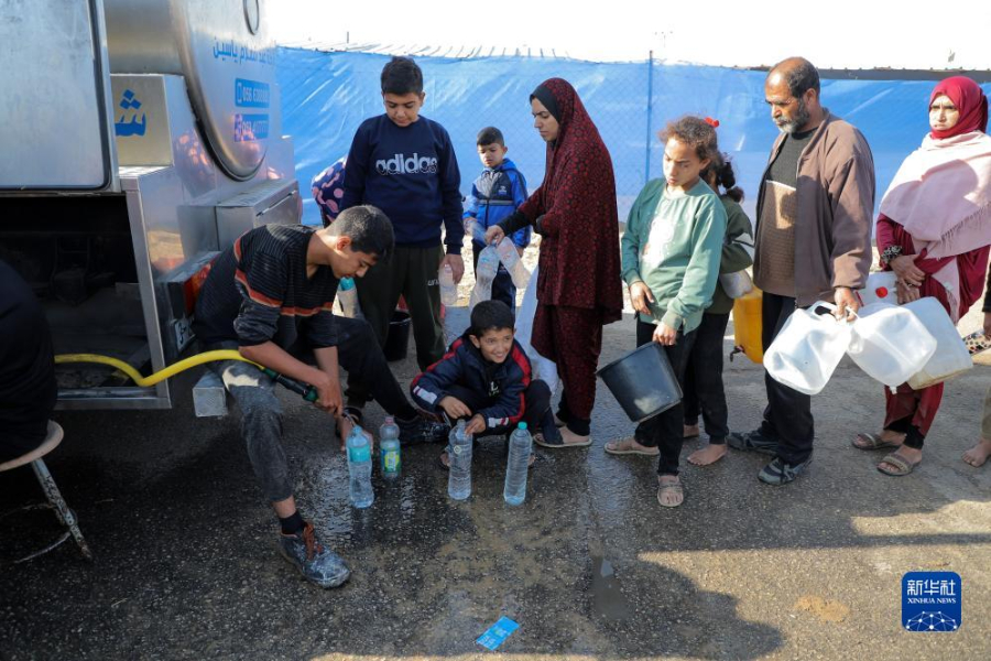 12月8日，在加沙地帶南部城市拉法一處臨時(shí)營(yíng)地內(nèi)，人們排隊(duì)打水。新華社發(fā)（里澤克·阿卜杜勒賈瓦德 攝）