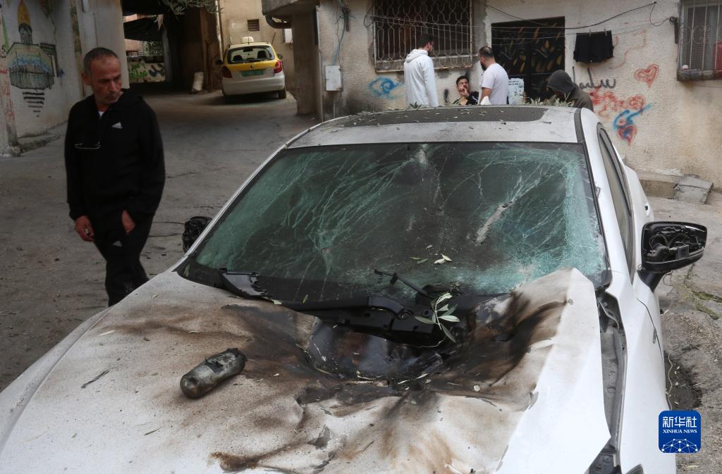 12月17日，在約旦河西岸城市圖勒凱爾姆附近的一處難民營，人們查看在沖突中損毀的車輛。新華社發(fā)（尼達(dá)爾·艾仕塔耶?dāng)z）