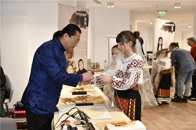 圖為羅馬尼亞小學(xué)生在現(xiàn)場體驗烙畫。 布加勒斯特中國文化中心供圖