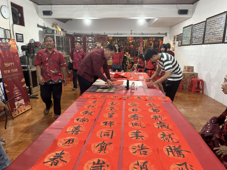 茍皓東為華人朋友現(xiàn)場寫春聯(lián)送福字。巴陵康孔子學(xué)院供圖