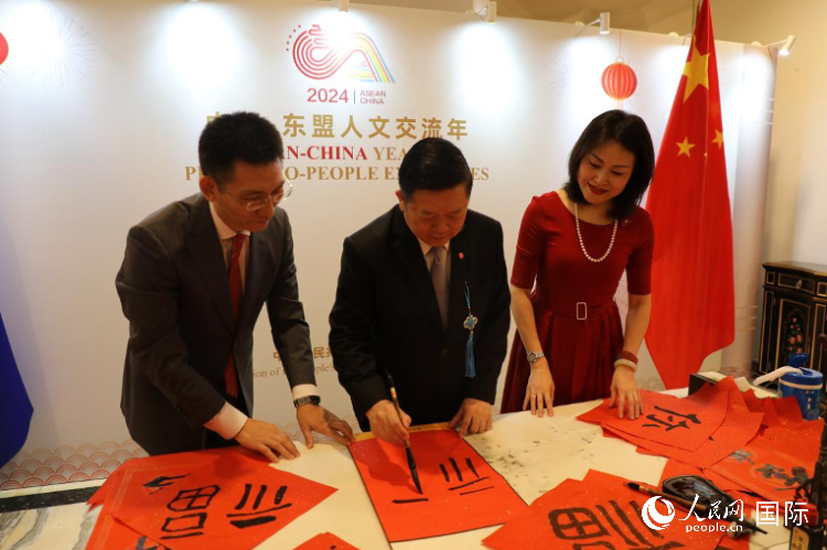 東盟秘書長高金洪（中）在活動(dòng)現(xiàn)場(chǎng)寫福字。人民網(wǎng)記者曹師韻攝