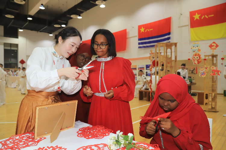 中國(guó)剪紙藝術(shù)吸引當(dāng)?shù)厝耸繀⑴c體驗(yàn)。陳錦俊攝