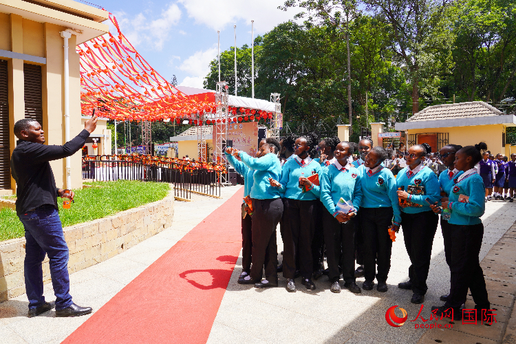 一名老師在給學(xué)生拍照留念。人民網(wǎng)記者 黃煒鑫攝