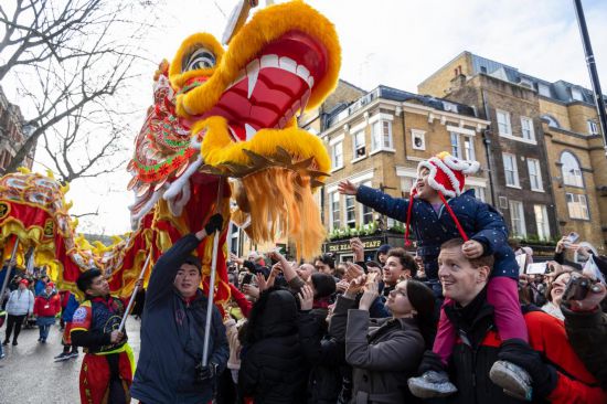 2月11日，人們在英國倫敦的新春巡游活動中觀看舞龍表演。新華社發(fā)（史蒂芬·程攝）