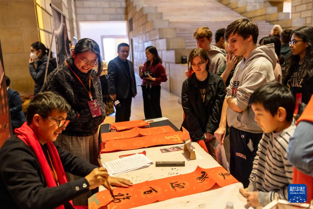 2月11日，書法家在美國費(fèi)城藝術(shù)博物館舉行的龍年迎新春活動(dòng)上為參觀者書寫對(duì)聯(lián)。新華社發(fā)（周煥新攝）