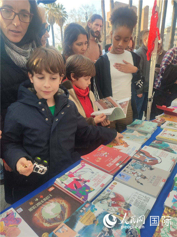印刷精美的中國傳統(tǒng)文化叢書吸引了小游客的注意。人民網(wǎng)記者鄭彬攝
