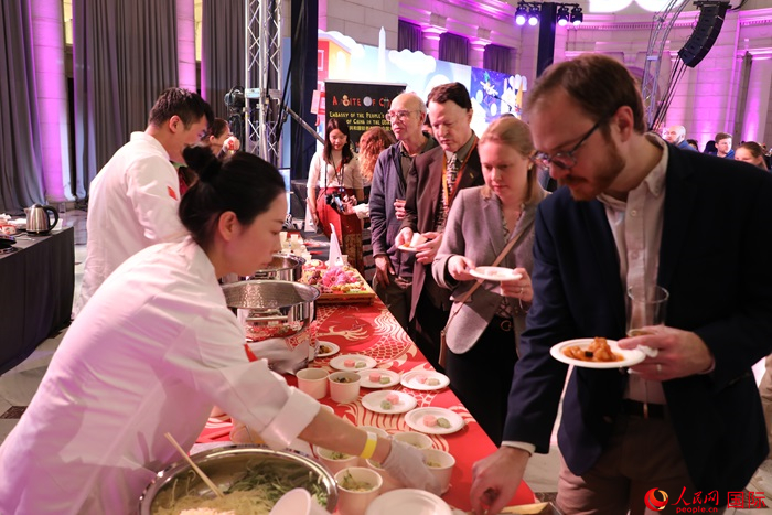 當(dāng)?shù)貢r(shí)間3月7日晚，華盛頓聯(lián)合車站廣場(chǎng)舉行駐美使團(tuán)“使館主廚挑戰(zhàn)賽”。圖為當(dāng)?shù)孛癖娫谥袊?guó)展臺(tái)前體驗(yàn)中國(guó)美食。人民網(wǎng)記者 李志偉攝