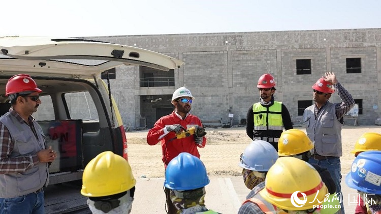 穆薩瓦爾(圖中紅衣人）現(xiàn)場(chǎng)演示工具操作規(guī)范。人民網(wǎng)記者 管克江攝