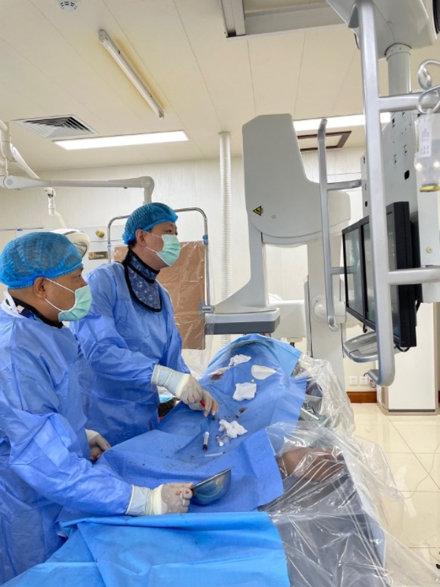 李凱教授（右）和劉海濤教授（左）為患者行TACE手術。中國駐老撾大使館供圖