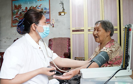 護(hù)理團(tuán)隊醫(yī)生為老人測量血壓。 陳佳兵攝
