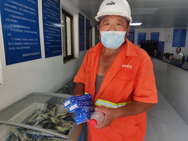 1環(huán)衛(wèi)工倪建宏小憩后，為還同事帶去冷飲。人民網(wǎng)記者王繼亮攝