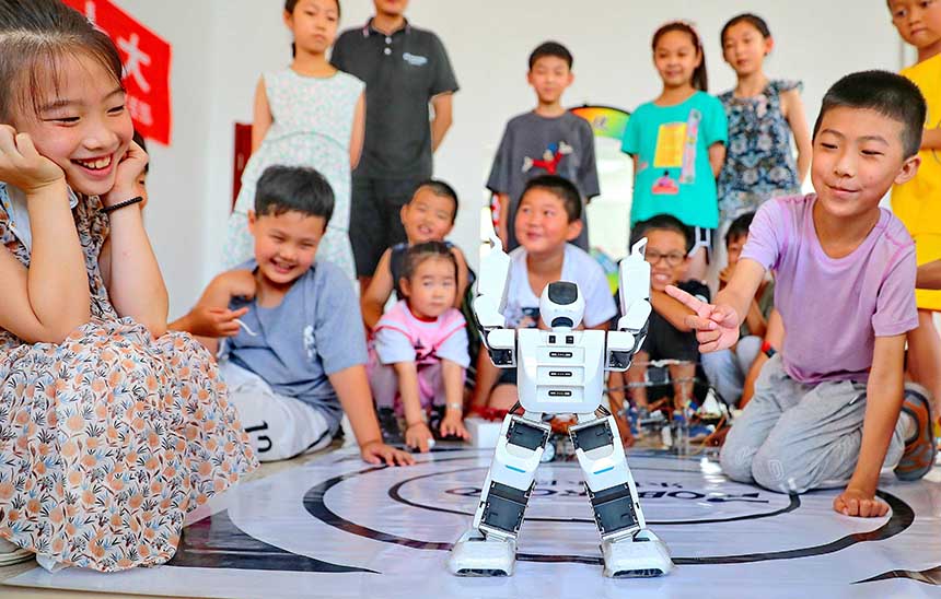 2022年7月19日，河北省秦皇島市海港區(qū)白塔嶺街道秦皇半島第二社區(qū)內，小朋友正在觀看“機器人跳舞”。 曹建雄攝