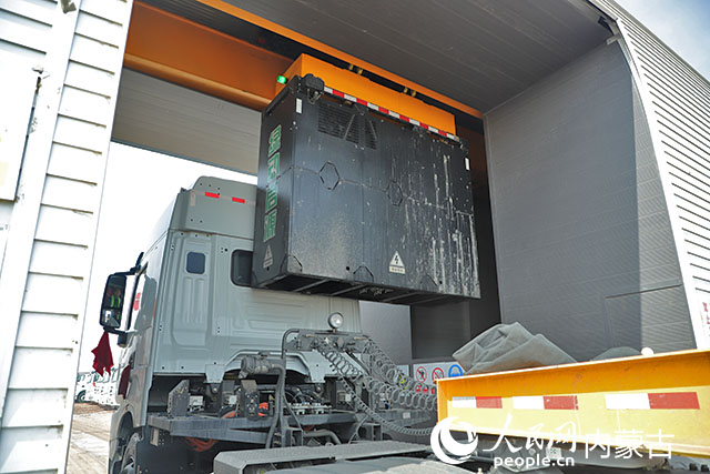 萬利新能源數(shù)字陸港里，正在充換電站進行換電的重卡。人民網(wǎng)記者 趙夢月攝