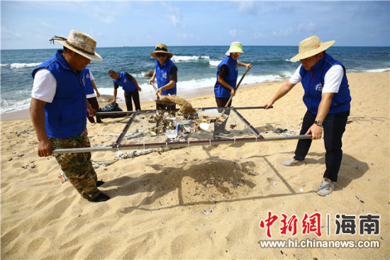 環(huán)保志愿者用篩網(wǎng)“淘”出海灘上的垃圾。