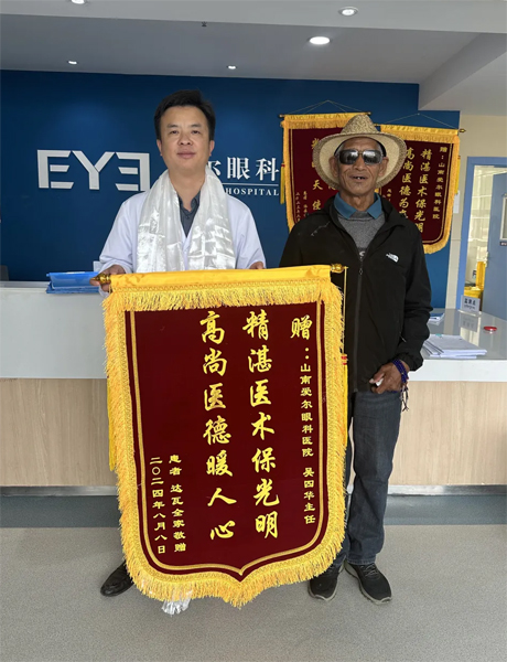 達(dá)瓦老人向吳四華（左）贈(zèng)送錦旗。受訪者供圖