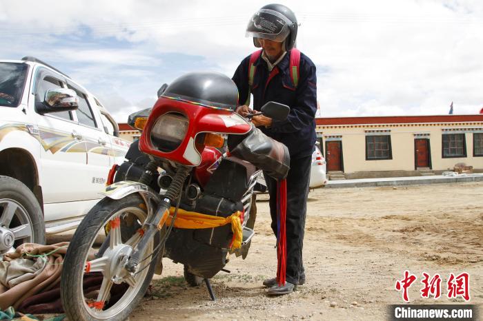 圖為白瑪準備騎摩托車巡湖。　趙朗 攝