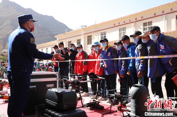 圖為消防指戰(zhàn)員為學生講解、演示先進救援裝備?！≮w琳 攝