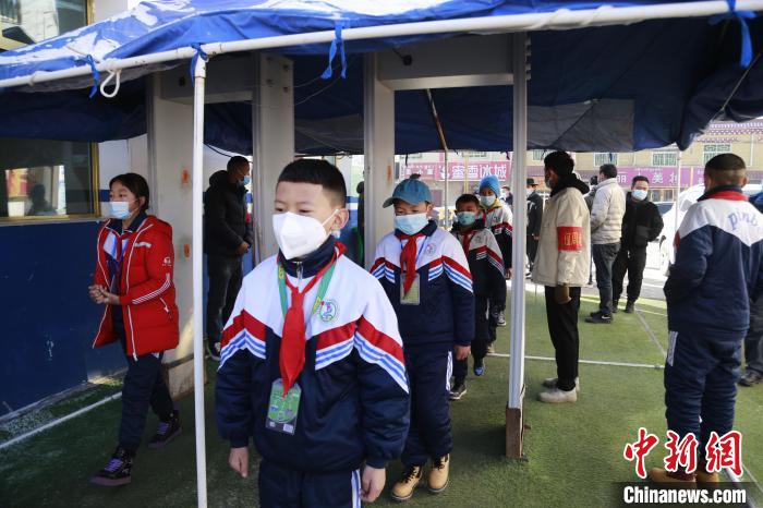 圖為學(xué)生測量體溫后進入校園。　馬銘言 攝